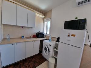 a kitchen with a refrigerator and a washing machine at Beau 2 pièces et Beau studio clair en plein centre ville Netanya in Netanya