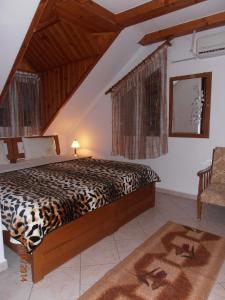 a bedroom with a leopard print bed and a chair at Guesthouse Agnandi in Kato Loutraki