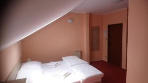 Cette chambre comprend un lit avec des oreillers blancs. dans l'établissement Restaurace-Pension-Vinařství U Šťastných, à Mistřín