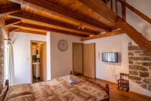 1 dormitorio con 1 cama y TV en la pared en Apartments Loriana, en Šibenik