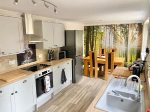 a kitchen with white cabinets and a dining room at Peaceful Country Cottage - views/walks - New 2022 in Lincoln