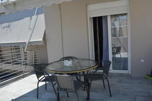 - Balcón con mesa y sillas y mesa de cristal en The Athenian Penthouse Residence, en Atenas