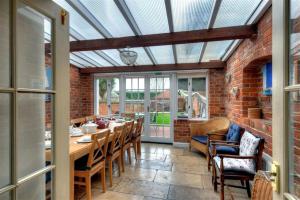 a conservatory with a table and chairs and a brick wall at The White House in Bridport