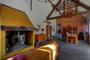 sala de estar con chimenea, sofá y mesa en The Forge en Rousdon