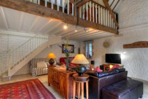 a living room with a couch and a staircase at The Forge in Rousdon