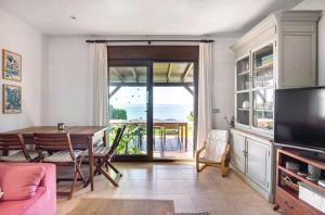 ein Wohnzimmer mit einem Tisch und einem TV in der Unterkunft Beach House in La Cala de Mijas