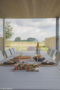 a table with two glasses of wine and food on it at Lavendelhof luxe wellnesshouse in Zottegem