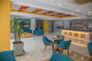 卡利的住宿－Hotel Estancia Chipichape Cali，一间设有蓝色椅子和桌子的等候室