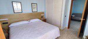 a bedroom with a white bed and a couch at Hotel Don Ignacio in San José