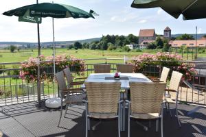 - une table avec des chaises et un parasol sur la terrasse dans l'établissement Landgasthof Zur scharfen Ecke, à Hildesheim