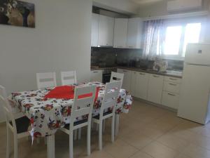 Una cocina con mesa y sillas y un refrigerador. en Ismene Apartments, en Argostoli