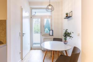 a dining room with a white table and chairs at Glück Auf Appartements Hufelandstraße Essen in Essen
