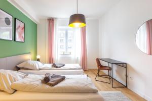 2 łóżka w pokoju ze stołem i krzesłem w obiekcie Glück Auf Appartements Hufelandstraße Essen w Essen