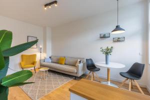 a living room with a couch and chairs and a table at Glück Auf Appartements Hufelandstraße Essen in Essen