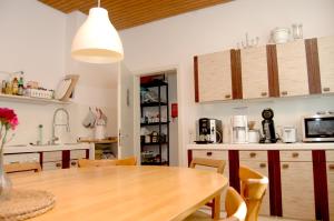 a kitchen with a wooden table and a dining room at Altes Schulhaus in Argenbühl