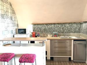 een keuken met een tafel en 2 krukken bij Studio de charme avec grande terrasse vue mer in Le Castellet