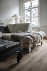 a living room with a couch with a fur blanket at Residence City House De Rozenboom in Leeuwarden