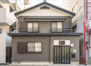 a gray house with a gambrel roof at Japanese traditional house.Ryokan in asakusa with 2bedrooms in Tokyo