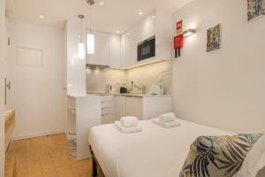 Cette chambre blanche dispose d'un lit et d'une cuisine. dans l'établissement Alfama's Heart Studio by LovelyStay, à Lisbonne