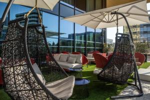 - une terrasse avec des chaises longues et un parasol dans l'établissement Crowne Plaza - Nice - Grand Arenas, an IHG Hotel, à Nice