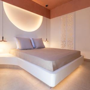 a bedroom with a bed with a large light above it at Kykladonisia Traditional Settlement in Fira