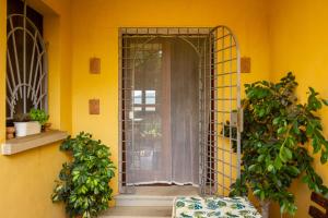 una entrada a una habitación amarilla con puerta y plantas en CASE&COLLINE Bella Vista, en Guardistallo