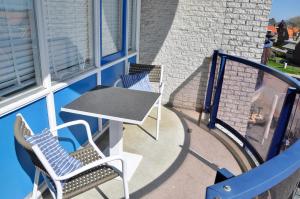 patio z 2 krzesłami i stołem oraz budynek w obiekcie Petten Beach 13 w mieście Petten