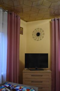 telewizor na komodzie w sypialni z zasłonami w obiekcie Domek na wsi-agroturystyka w mieście Czyże