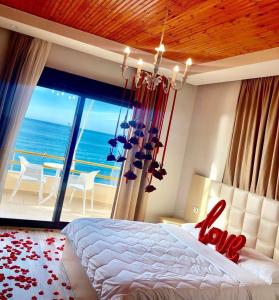 a bedroom with a bed with a view of the ocean at Hotel Lungomare in Vlorë