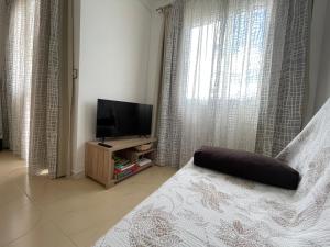 een slaapkamer met een bed en een televisie en gordijnen bij Ocean Sunrise in Costa de Antigua