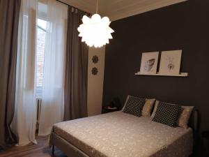 a bedroom with a bed and a chandelier at AUXIMUM Appartamenti in Osimo +21 photos