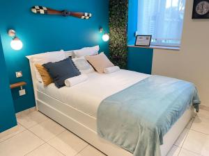 ein Schlafzimmer mit einem großen Bett mit blauen Wänden in der Unterkunft ☆ Les pieds sur terre ☆ tout confort ☆ NETFLIX ☆ in Metz