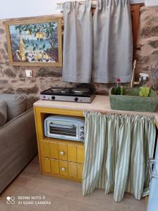 uma sala de estar com uma mesa com um fogão em Περιβόλι του Οδυσσέα em Volissos