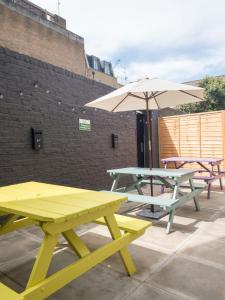 two picnic tables and an umbrella on a patio at Smart Camden Inn in London