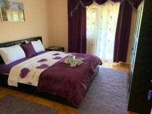 een slaapkamer met een bed met paarse lakens en een raam bij Vila Siki in Rakari