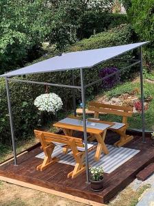 a picnic table and a bench with a canopy at Vila Siki in Rakari