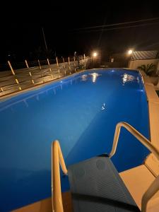 a blue swimming pool at night with a chair at Villa Torre Magaggiari in Cinisi