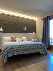 a bedroom with a large bed and a window at Hostal Pedraforca in Saldés