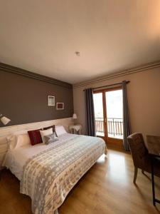 een slaapkamer met een groot bed en een balkon bij Hostal Pedraforca in Saldés