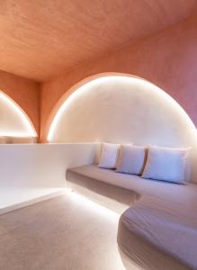 a room with two beds and a round window at Kykladonisia Traditional Settlement in Fira