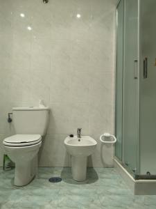 a bathroom with a toilet and a sink and a shower at Primera Linea de Playa Samil Costa con Garaje Incluido in Vigo