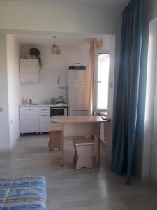 una pequeña cocina con mesa y nevera en Светлая квартира для гостей, en Kyzylorda
