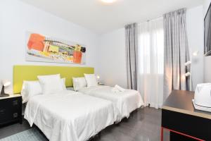 Una habitación de hotel con dos camas y una ventana. en Hotel Kuve Marbella, en Marbella