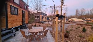 a tiny house with a table and chairs in a yard at Vakantiepark 't Urkerbos -Tiny house in Urk