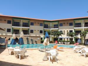 a hotel with a pool and chairs and umbrellas at Ap Luxo 208 e 207 Prox Beach Park in Aquiraz