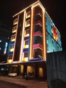 um edifício iluminado com uma moto estacionada em frente em Hotel Bramha Inn em Dāpuri