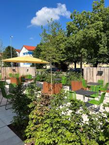 a patio with a table and chairs and an umbrella at Hotel Zeppelin in Laupheim
