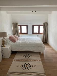 a bedroom with a large bed and a rug at Vivegnis, little cosy house in Liège