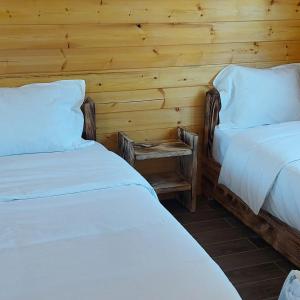 a bedroom with two beds and a nightstand between them at Camping Farm Shelegur in Leskovik