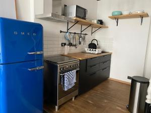 cocina con nevera azul y fogones en Vivegnis, little cosy house, en Lieja